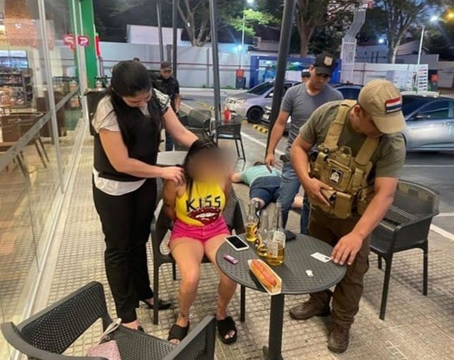 Brisa Leguizamón es retenida por efectivos policiales en un bar de Asunción.