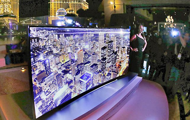 Una modelo posa al lado de la nueva pantalla curva de televisores de alta definición de 105 pulgadas (2