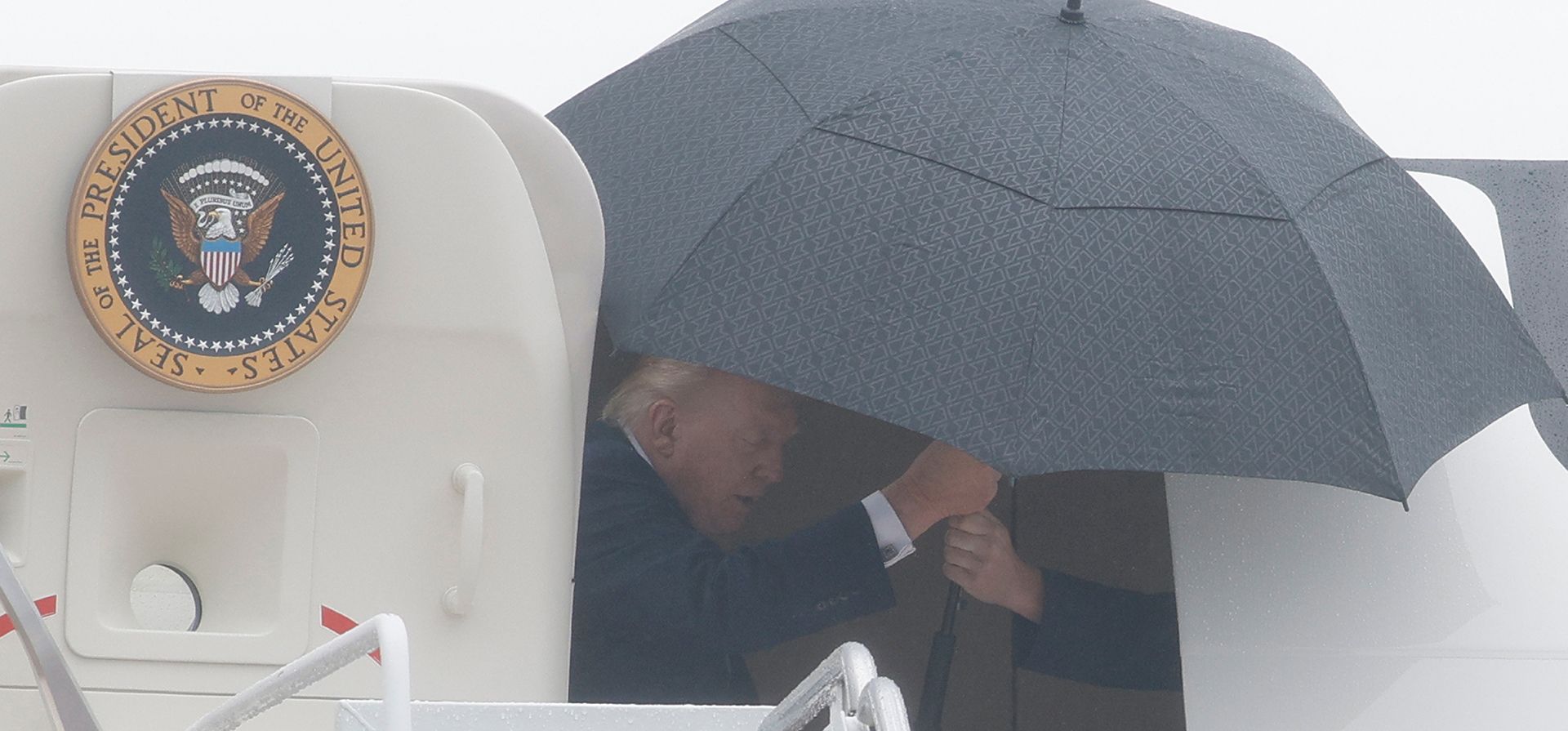 El presidente Donald Trump recibe un paraguas a su llegada a la Base Conjunta Andrews, al bajar del Air Force One, Maryland, el domingo 2 de agosto de 2026. (Foto AP/Luis M. Alvarez) El presidente Donald Trump recibe un paraguas a su llegada a la Base Conjunta Andrews, al bajar del Air Force One, Maryland, el domingo 2 de agosto de 2026. (Foto AP/Luis M. Alvarez)