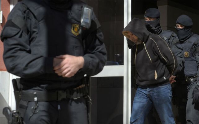 Arrestos. Uno de los terroristas es trasladado esposado en Cataluña.