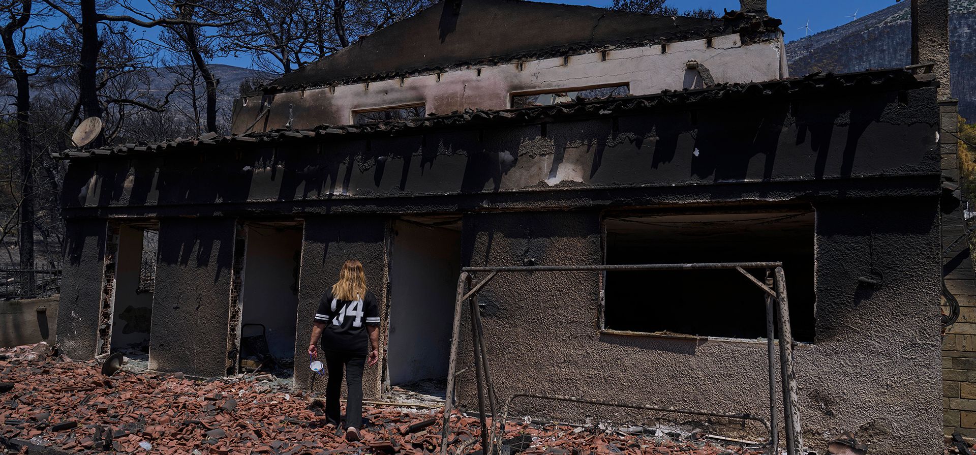 Charoula Spanou camina hacia los restos de su casa de vacaciones destruida por un incendio forestal en Porto Germeno, al noroeste de Atenas, Grecia, el martes 4 de agosto de 2026. (Foto AP/Petros Giannakouris) Charoula Spanou camina hacia los restos de su casa de vacaciones destruida por un incendio forestal en Porto Germeno, al noroeste de Atenas, Grecia, el martes 4 de agosto de 2026. (Foto AP/Petros Giannakouris)