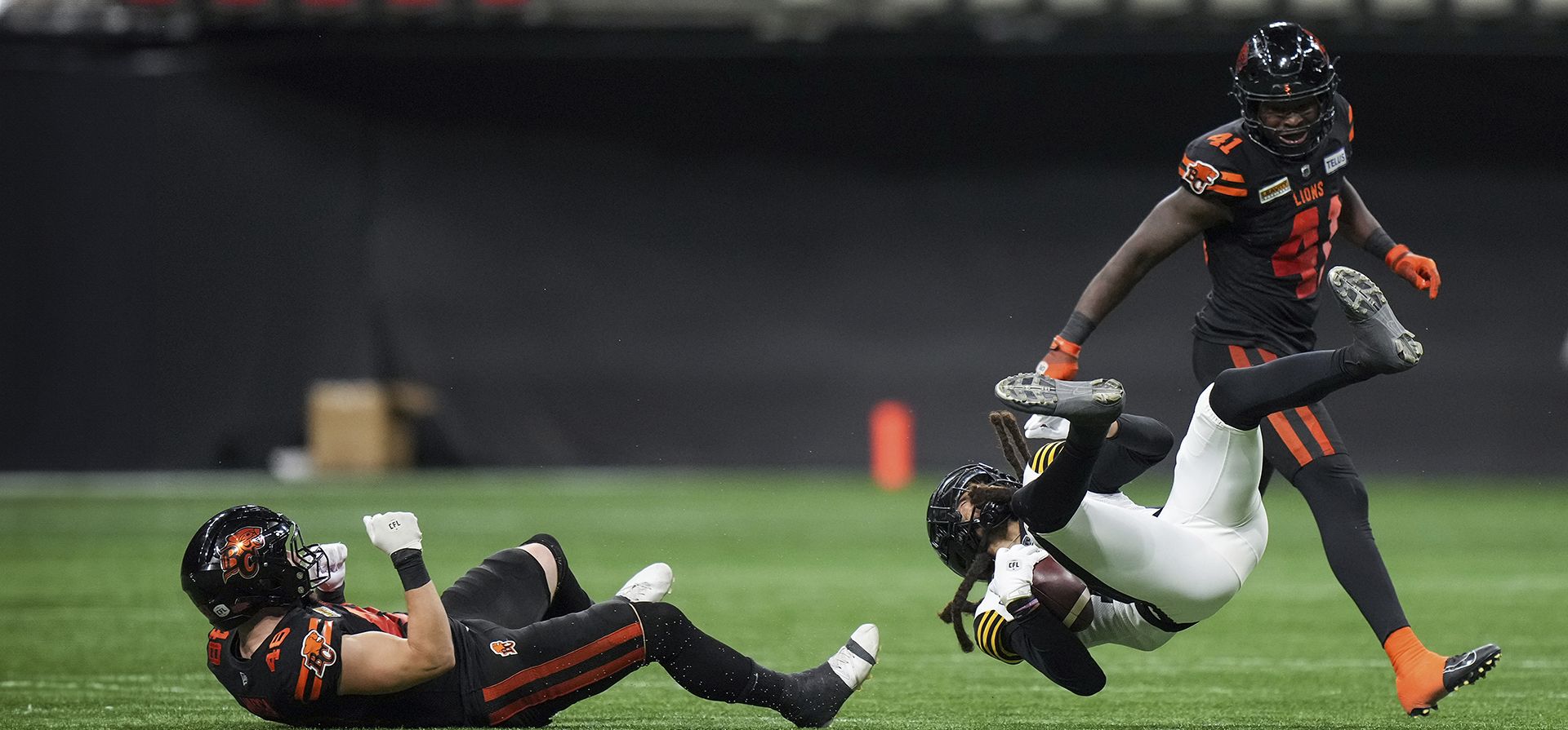 Shemar Bridges, de Hamilton Tiger-Cats, al frente a la derecha, es derribado por Ryder Varga, de B.C. Lions, a la izquierda, frente a Ayinde Eley, atrás a la derecha, durante la segunda mitad de un partido de fútbol de la CFL, en Vancouver, el viernes 27 de septiembre de 2024. (Darryl Dyck/The Canadian Press vía AP) Shemar Bridges, de Hamilton Tiger-Cats, al frente a la derecha, es derribado por Ryder Varga, de B.C. Lions, a la izquierda, frente a Ayinde Eley, atrás a la derecha, durante la segunda mitad de un partido de fútbol de la CFL, en Vancouver, el viernes 27 de septiembre de 2024. (Darryl Dyck/The Canadian Press vía AP)