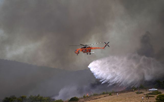 Un helicóptero arroja agua sobre un incendio en el pueblo de Siderina a unos 55 kilómetros al sur de Atenas