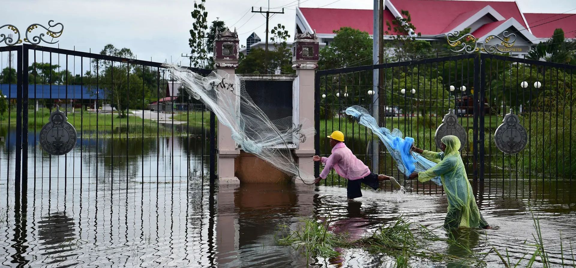 Narathiwat, Tailandia. Hombres lanzan redes mientras pescan en las inundaciones tras las fuertes lluvias en la provincia sureña de Tailandia. Fotografía: Madaree Tohlala/AFP/Getty Images
