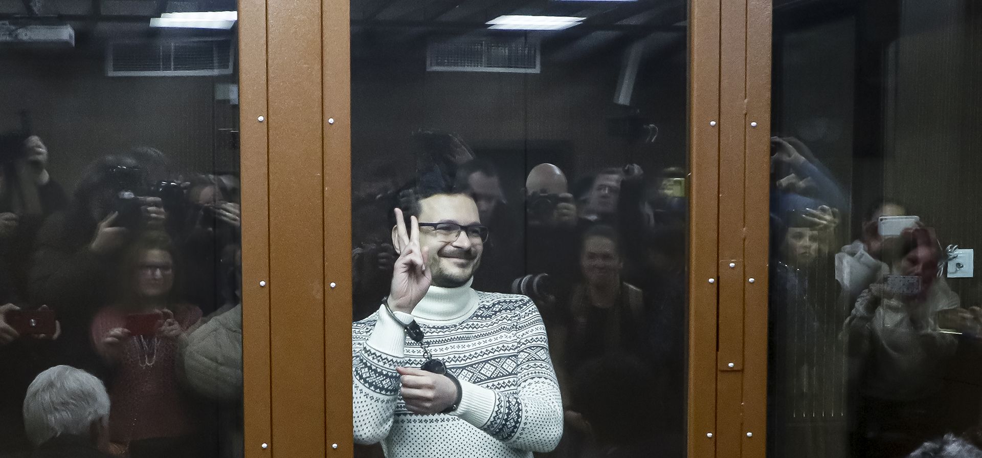 El activista de la oposición rusa y exdiputado municipal del distrito de Krasnoselsky, Ilya Yashin, hace un gesto mientras está de pie dentro de un cubículo de vidrio en una sala del tribunal antes de una audiencia en Moscú, Rusia, el viernes 9 de diciembre de 2022. Yashin fue sentenciado a 8 1/2 años de prisión por cargos derivados de sus críticas a la acción del Kremlin en Ucrania. (Yury Kochetkov/Pool Photo vía AP)