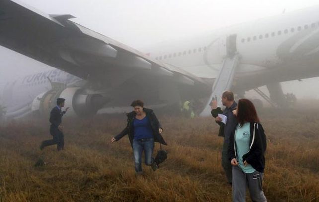Los pasajeros abandonan el avión en medio de la espesa niebla.