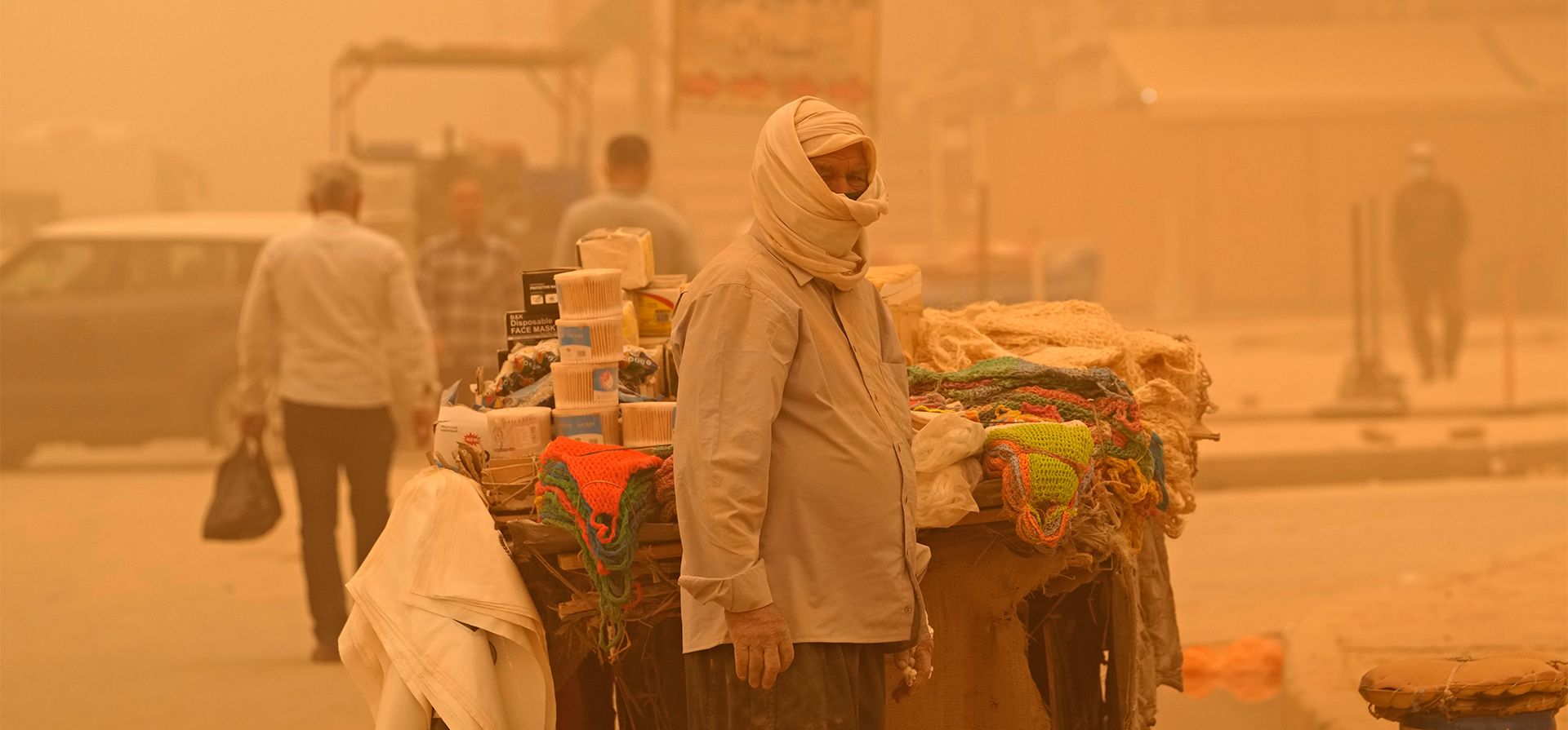 Un vendedor ambulante espera a los clientes durante una tormenta de arena en Bagdad, Irak, el lunes 16 de mayo de 2022. Varios centros de salud recibieron también a decenas de pacientes con dificultades para respirar, mientras que las administraciones públicas cerraron sus puertas por precaución.