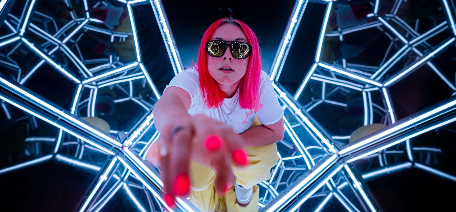 Rhi Davies juega con su reflejo dentro de una estructura espejada mientras se hacen los preparativos finales para la apertura de lo que se anuncia como el primer