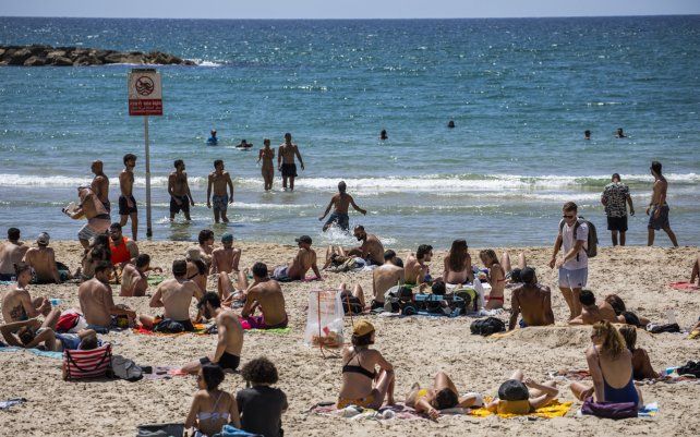 La gente disfruta de un día de playa en Tel Aviv, Israel, en medio de la escalada de violencia israelí-palestina.