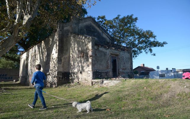 La casona rodeada de un espacio verde que limpian los vecinos para que jueguen los chicos del barrio..