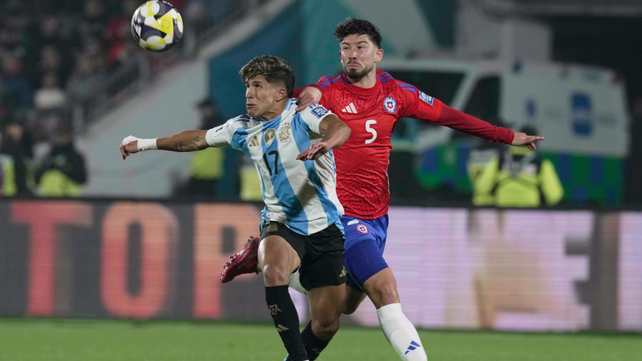 Giovani Simeone disputa la pelota con Loyola. El delantero de la selección argentina tuvo un interesante partido.