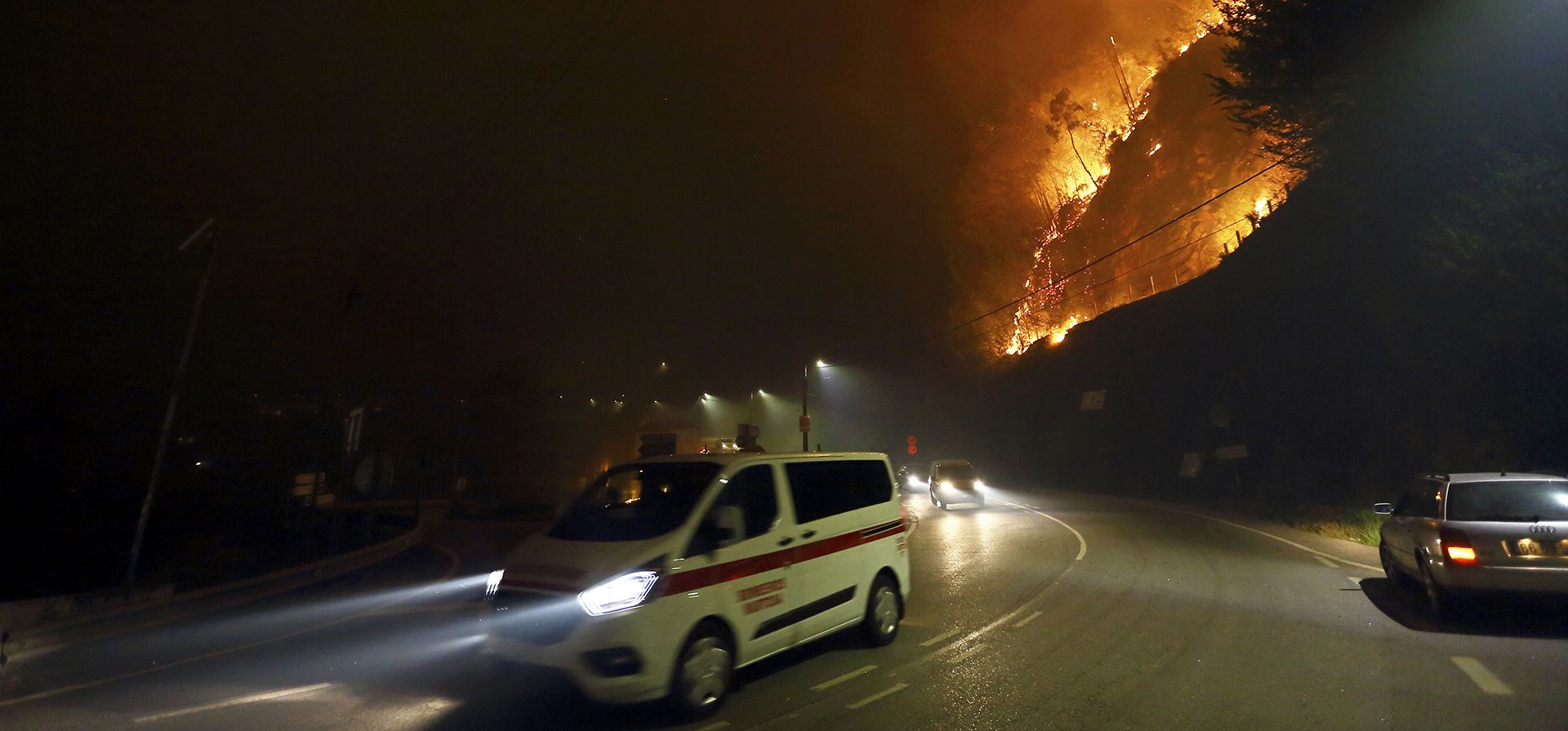 Vehículos pasan junto a un incendio que arde en la carretera cerca de Sever do Vouga, una ciudad en el norte de Portugal que ha estado rodeada por incendios forestales, el lunes por la noche, 16 de septiembre de 2024. (Foto AP/Bruno Fonseca) Vehículos pasan junto a un incendio que arde en la carretera cerca de Sever do Vouga, una ciudad en el norte de Portugal que ha estado rodeada por incendios forestales, el lunes por la noche, 16 de septiembre de 2024. (Foto AP/Bruno Fonseca)