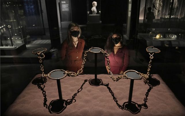 Empleadas del museo posan para los fotógrafos junto a las cadenas de bandas que datan del 100 a. C. al 78 d. C. que tenían a personas esclavizadas o prisioneros y fueron encontrados en un lago en la isla de Mona (hoy llamada Anglesey) en el noroeste de Gales.