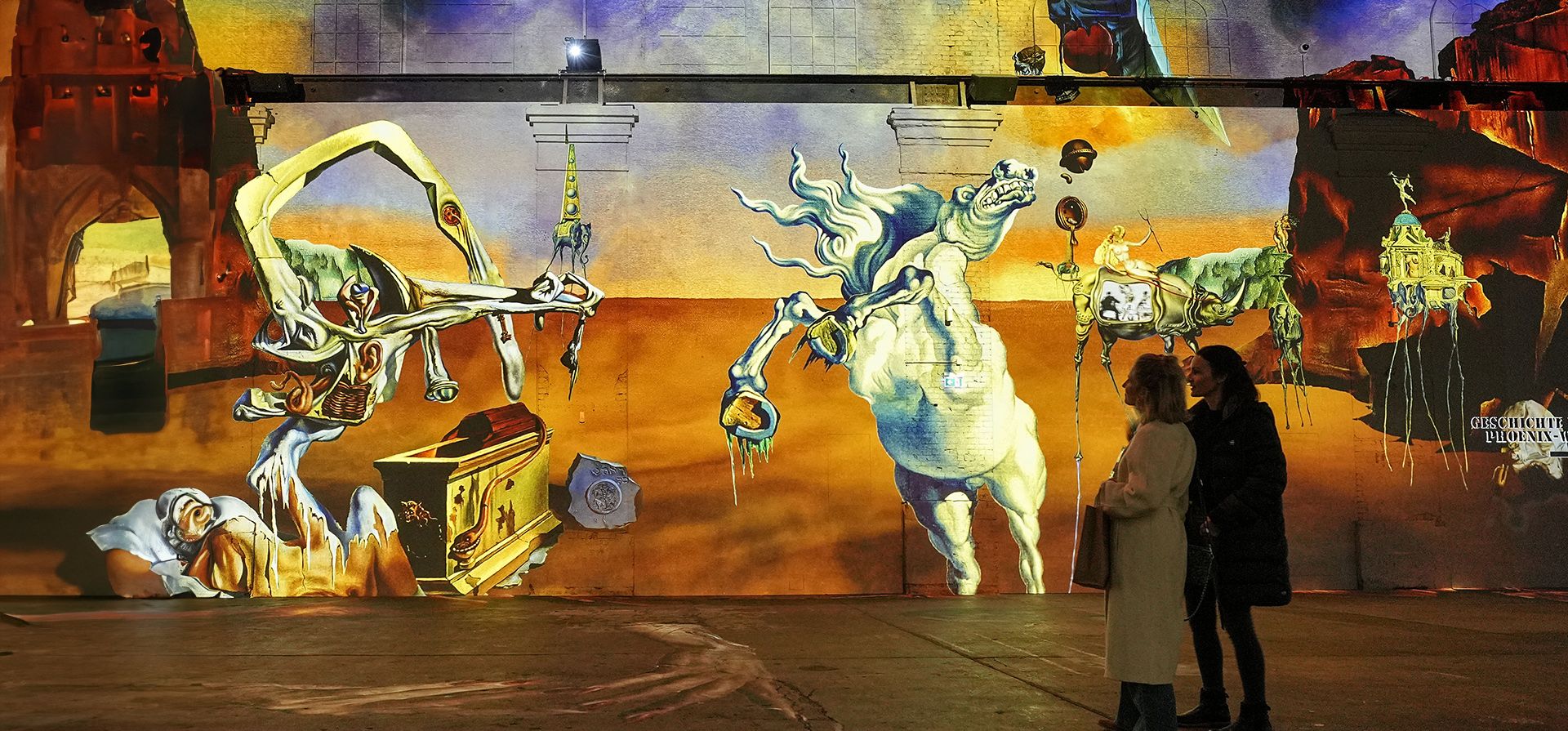 Visitantes ven obras de arte multimedia digitales proyectadas en las paredes de una antigua acería del artista surrealista español Salvador Dalí en el Phoenix des Lumieres, en Dortmund, Alemania, el jueves 25 de enero de 2024. (Foto AP /Martín Meissner) Visitantes ven obras de arte multimedia digitales proyectadas en las paredes de una antigua acería del artista surrealista español Salvador Dalí en el Phoenix des Lumieres, en Dortmund, Alemania, el jueves 25 de enero de 2024. (Foto AP /Martín Meissner)