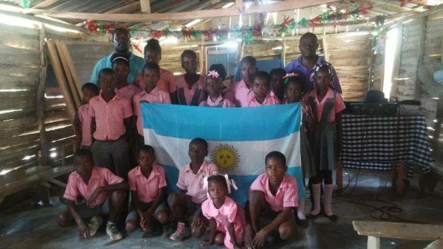 LOS CHICOS Y LA BANDERA. Un entrerriano fundó una escuela primaria en Haití