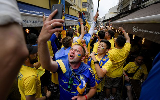 Hinchas de Ucrania cantan antes del partido del grupo C del campeonato de fútbol de la Eurocopa 2020 entre Ucrania y Austria en el distrito de la ciudad vieja de Bucarest