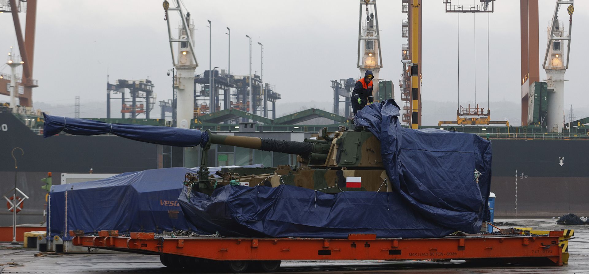 Un trabajador descubre un obús Thunder K9 de Corea del Sur en el puerto de la Armada polaca de Gdynia, Polonia, el martes 6 de diciembre de 2022. El presidente de Polonia, Andrzej Duda, y el ministro de Defensa dieron la bienvenida el martes a la primera entrega de tanques y obuses de Corea del Sur, elogiando la rápida implementación de un acuerdo firmado en el verano frente a la guerra en la vecina Ucrania. Foto: AP/Michal Dyjuk