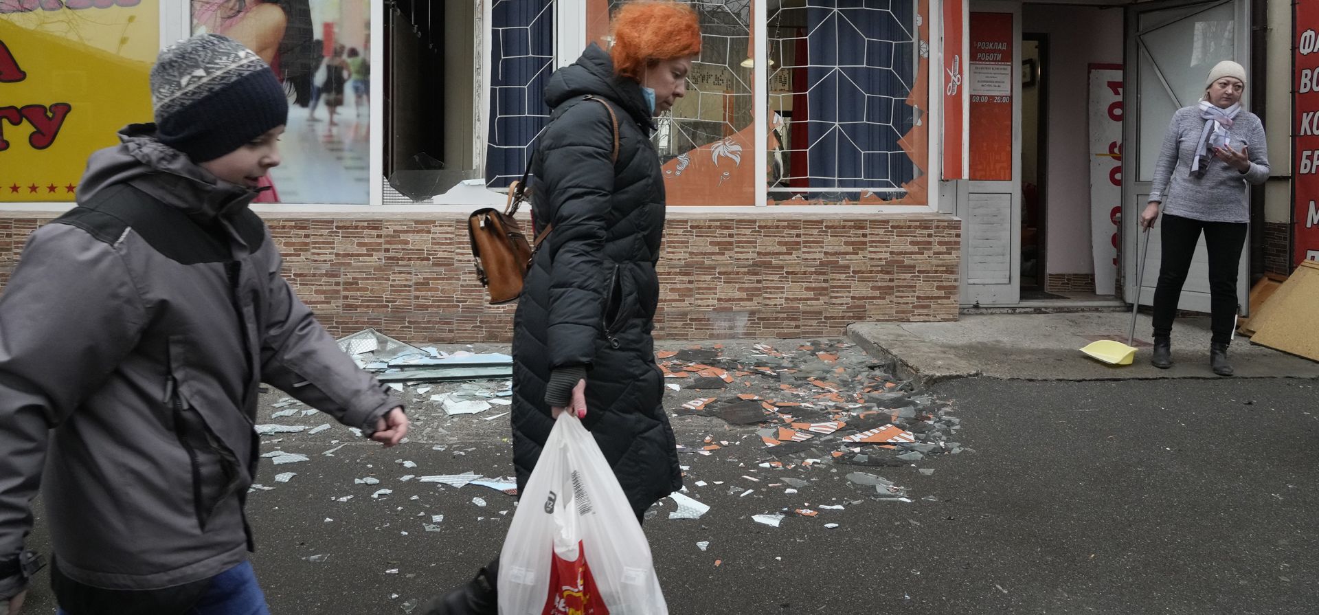 La gente pasa frente a las secuelas del bombardeo ruso en Kiev, Ucrania, el jueves 24 de febrero de 2022. Las tropas rusas lanzaron su ataque anticipado contra Ucrania.