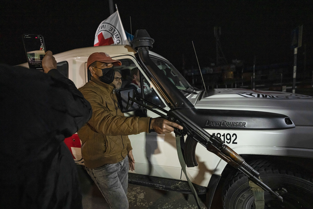 Un miliciano de Hamás custodia un vehículo de Cruz Roja que lleva rehenes liberados desde Gaza a Egipto.