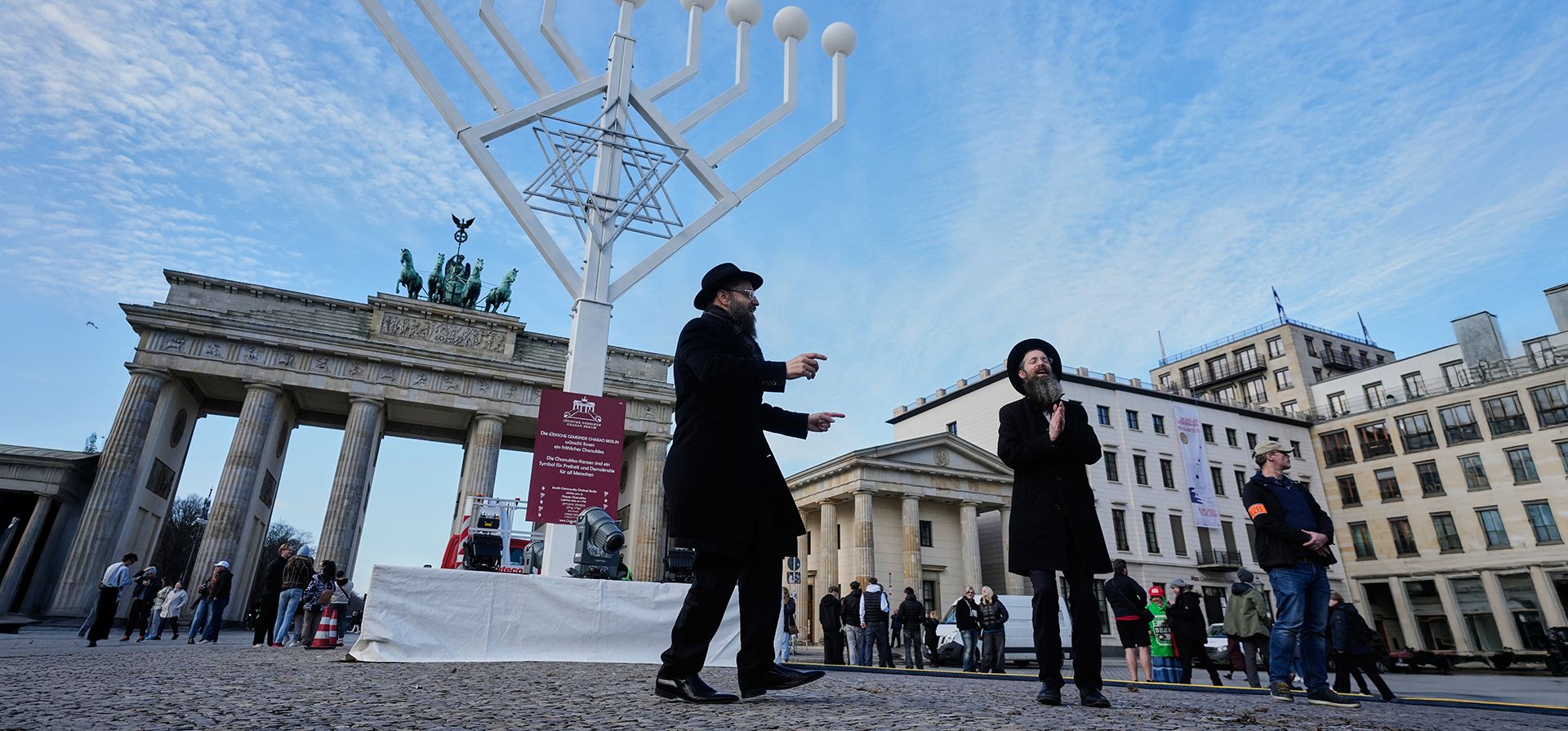 El rabino Yehuda Teichtal, a la izquierda, y el rabino Shmuel Segal, a la derecha, bailan durante la inauguración de una Menorá gigante de Janucá por parte del Centro Educativo Judío Jabad antes de la festividad judía de Janucá, frente a la Puerta de Brandeburgo en la Pariser Platz en Berlín, Alemania, el viernes 12 de diciembre de 2025. (Foto AP/Markus Schreiber) El rabino Yehuda Teichtal, a la izquierda, y el rabino Shmuel Segal, a la derecha, bailan durante la inauguración de una Menorá gigante de Janucá por parte del Centro Educativo Judío Jabad antes de la festividad judía de Janucá, frente a la Puerta de Brandeburgo en la Pariser Platz en Berlín, Alemania, el viernes 12 de diciembre de 2025. (Foto AP/Markus Schreiber)