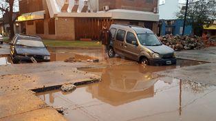 Dos autos cayeron en un bache lleno de agua de la lluvia