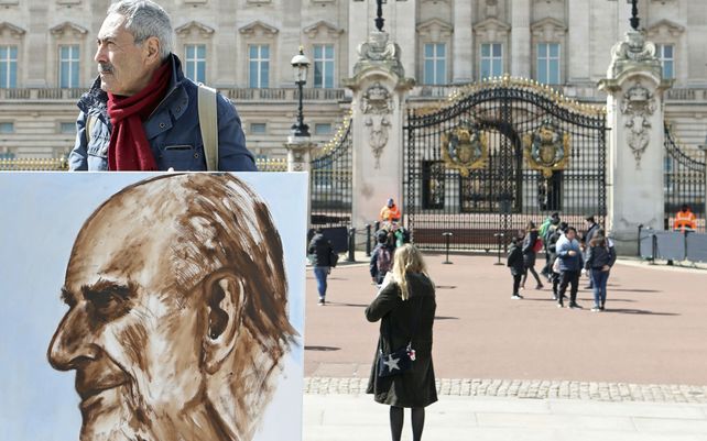 El artista Kaya Mar sostiene un retrato que pintó del duque de Edimburgo frente al Palacio de Buckingham. El príncipe Felipe de Gran Bretaña