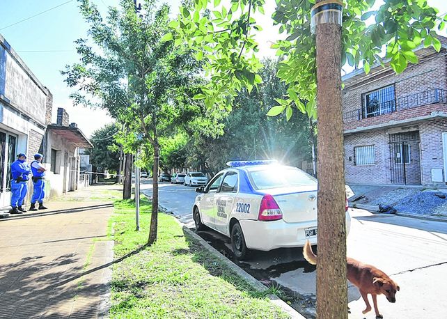 El día después. La policía apostada en la vereda opuesta a la casa de ladrillos donde ocurrió el múltiple homicidio.