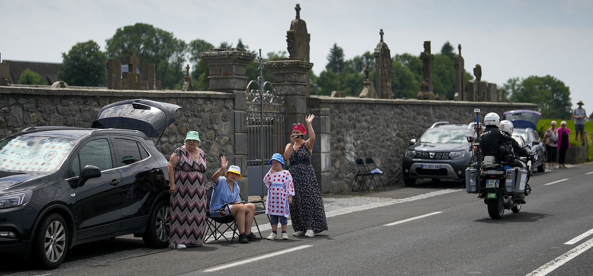 Los espectadores esperan a que los ciclistas pasen afuera de un cementerio durante la décima etapa de la carrera ciclista del Tour de Francia de 167 kilómetros con inicio en Vulcania y final en Issoire, Francia, el martes 11 de julio de 2023. (Foto AP/ Thibault Camus) Los espectadores esperan a que los ciclistas pasen afuera de un cementerio durante la décima etapa de la carrera ciclista del Tour de Francia de 167 kilómetros con inicio en Vulcania y final en Issoire, Francia, el martes 11 de julio de 2023. (Foto AP/ Thibault Camus)