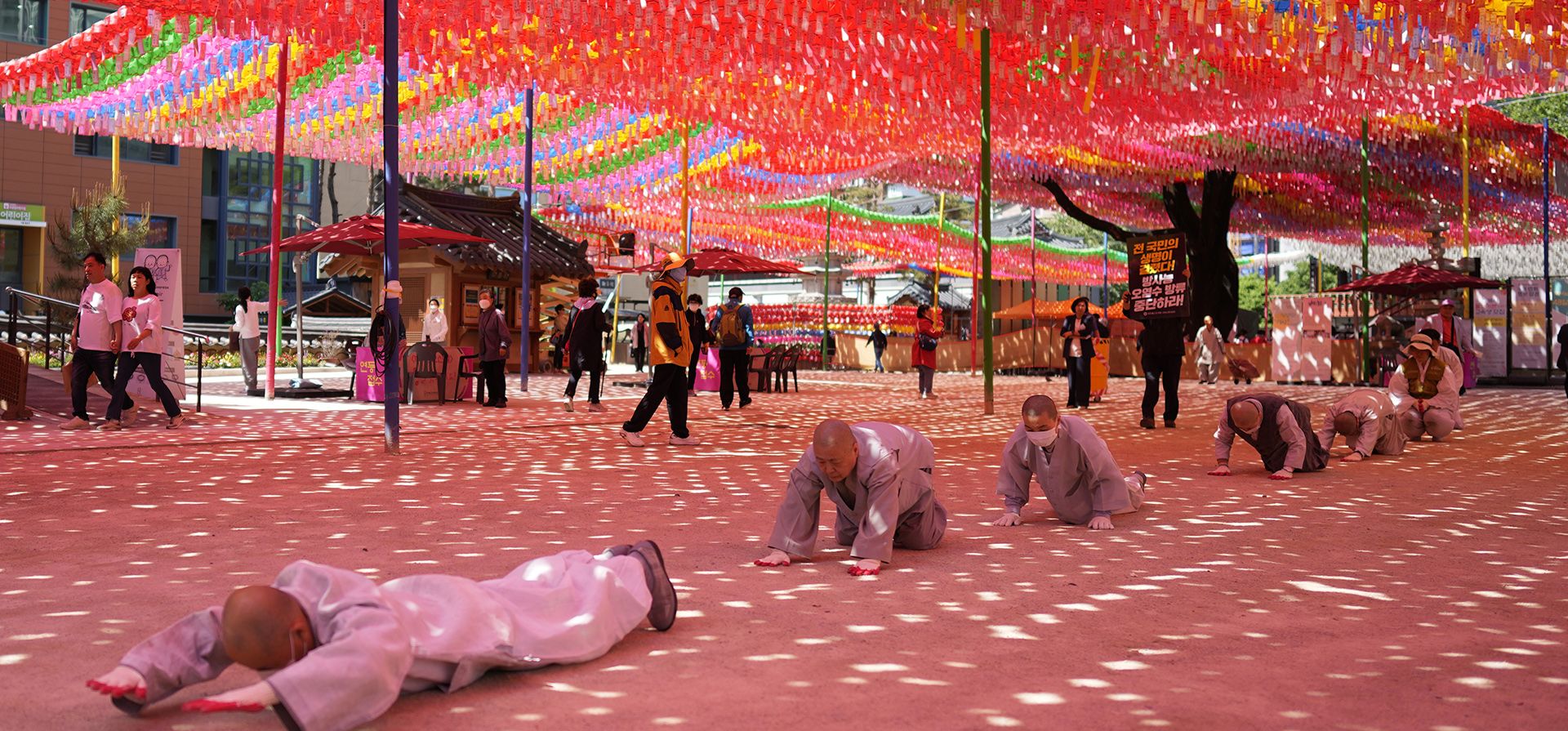Monjes budistas de Corea del Sur y miembros de grupos cívicos se inclinan y se postran, en una marcha durante un mitin exigiendo el cese de la decisión del gobierno japonés de liberar agua radiactiva tratada de Fukushima, en el templo Jogye en Seúl, Corea del Sur, el lunes. 8 de mayo de 2023. (Foto AP/Lee Jin-man)