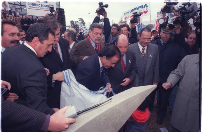 20 de junio de 1997. El presidente Menem descubre la piedra fundamental del puente en la cabecera de Rosario.  Y promete que esta obra del puente “será una realidad” y que en 1999 cuando termine su gobierno dejará a “la Argentina entre los diez mejores países de al tierra”. Lo primero lo cumplió, lo segundo demás está decir qué ocurrió.