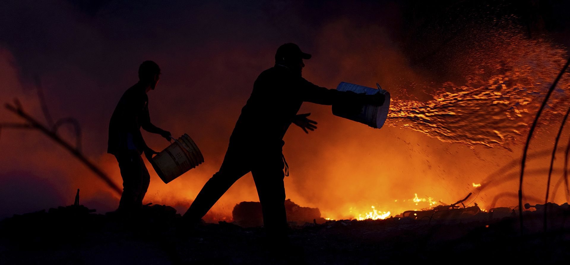 Residentes arrojan cubos de agua a las llamas que arrasan un vecindario en Salta, Argentina, el 1 de agosto de 2025. (AP Foto/Javier Corbalán) Residentes arrojan cubos de agua a las llamas que arrasan un vecindario en Salta, Argentina, el 1 de agosto de 2025. (AP Foto/Javier Corbalán)