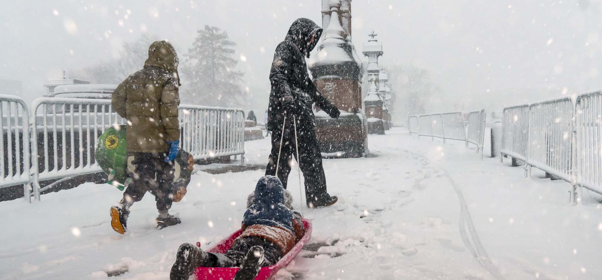 Un niño es arrastrado en un trineo mientras una tormenta invernal entrega una fuerte nevada al Capitolio en Washington. Foto: AP