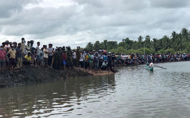 Habitantes de Sri Lanka observan el trabajo de rescate tras el vuelco de un ferry en Kinniya, a unos 267 kilómetros al este de Colombo, Sri Lanka, el martes 23 de noviembre de 2021. Al menos seis personas murieron después de que un ferry volcó en el este de Sri Lanka.