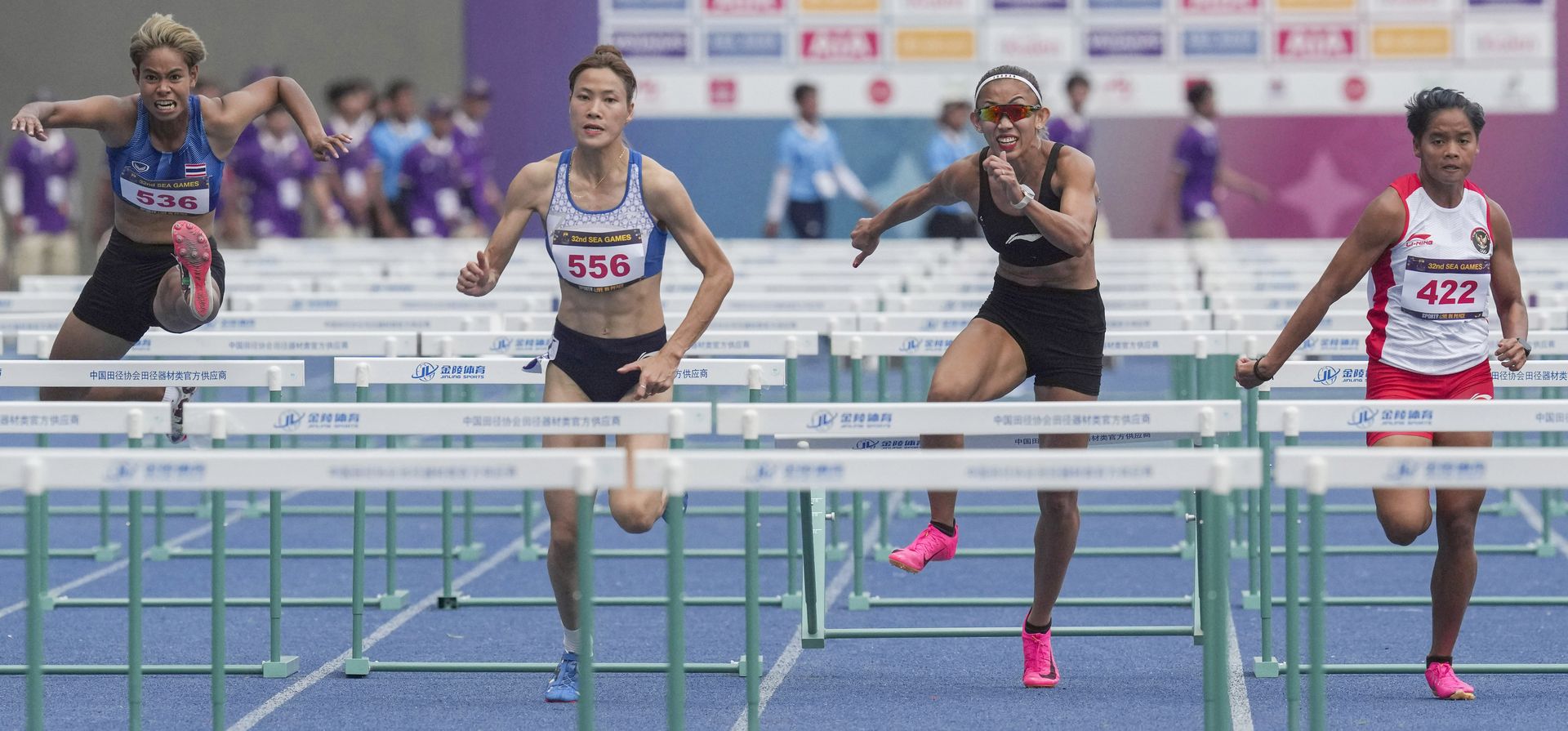 Atletas compiten en la final femenina de 100 metros con vallas durante la competencia de atletismo en los 32° Juegos del Sudeste Asiático en Phnom Penh, Camboya, el miércoles 10 de mayo de 2023. (Foto AP/Tatan Syuflana)