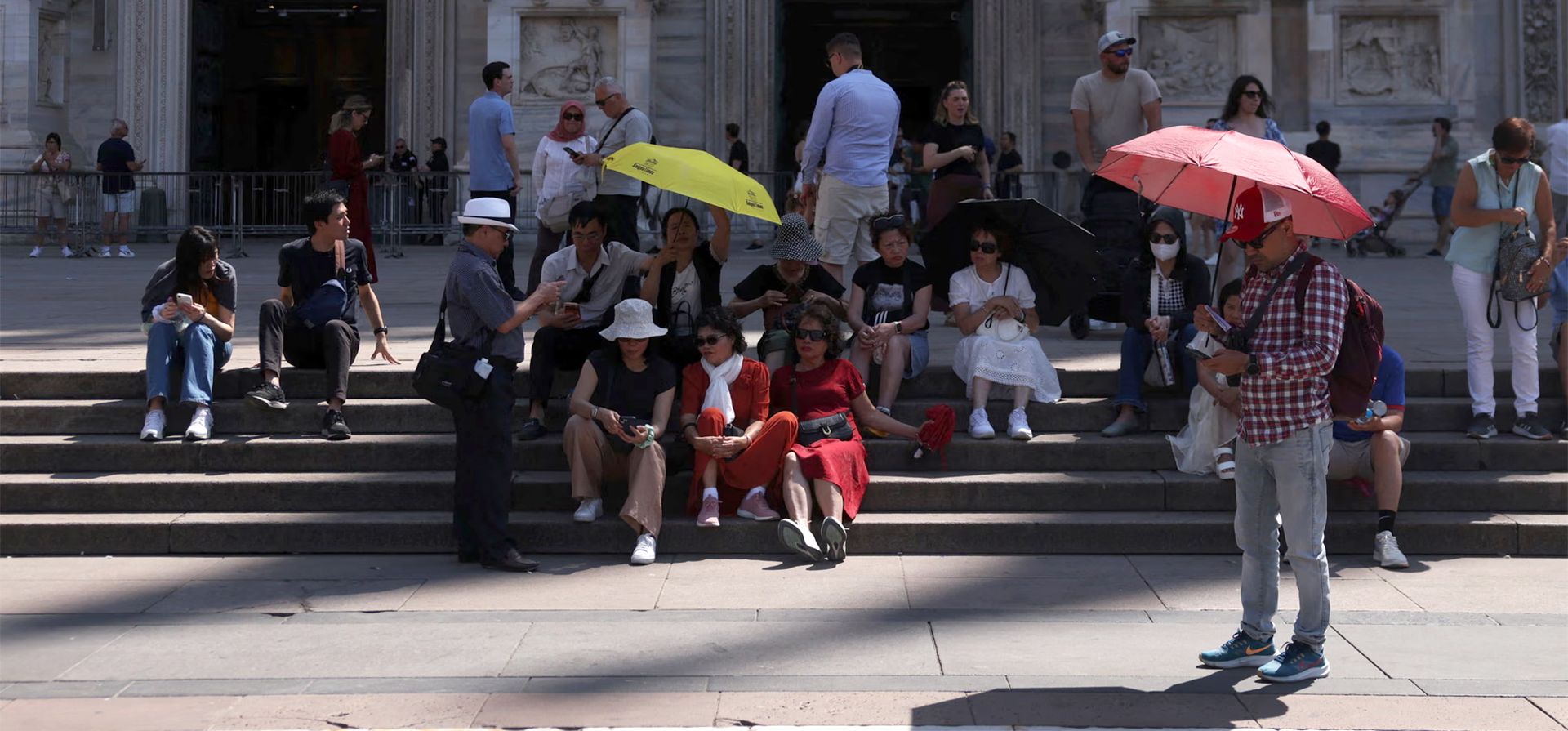 La gente se protege del sol con paraguas durante la ola de calor, junto a la catedral, Milán, Italia. Fotografía: Claudia Greco/Reuters La gente se protege del sol con paraguas durante la ola de calor, junto a la catedral, Milán, Italia. Fotografía: Claudia Greco/Reuters