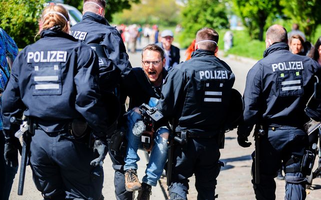 Agentes de policía de Berlín se llevan a un hombre durante una manifestación contra las medidas del gobierno por el COVID-19.
