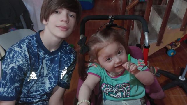 Nina junto a su hermano: A diario recibe terapeutas y la familia no deja de estimularla.