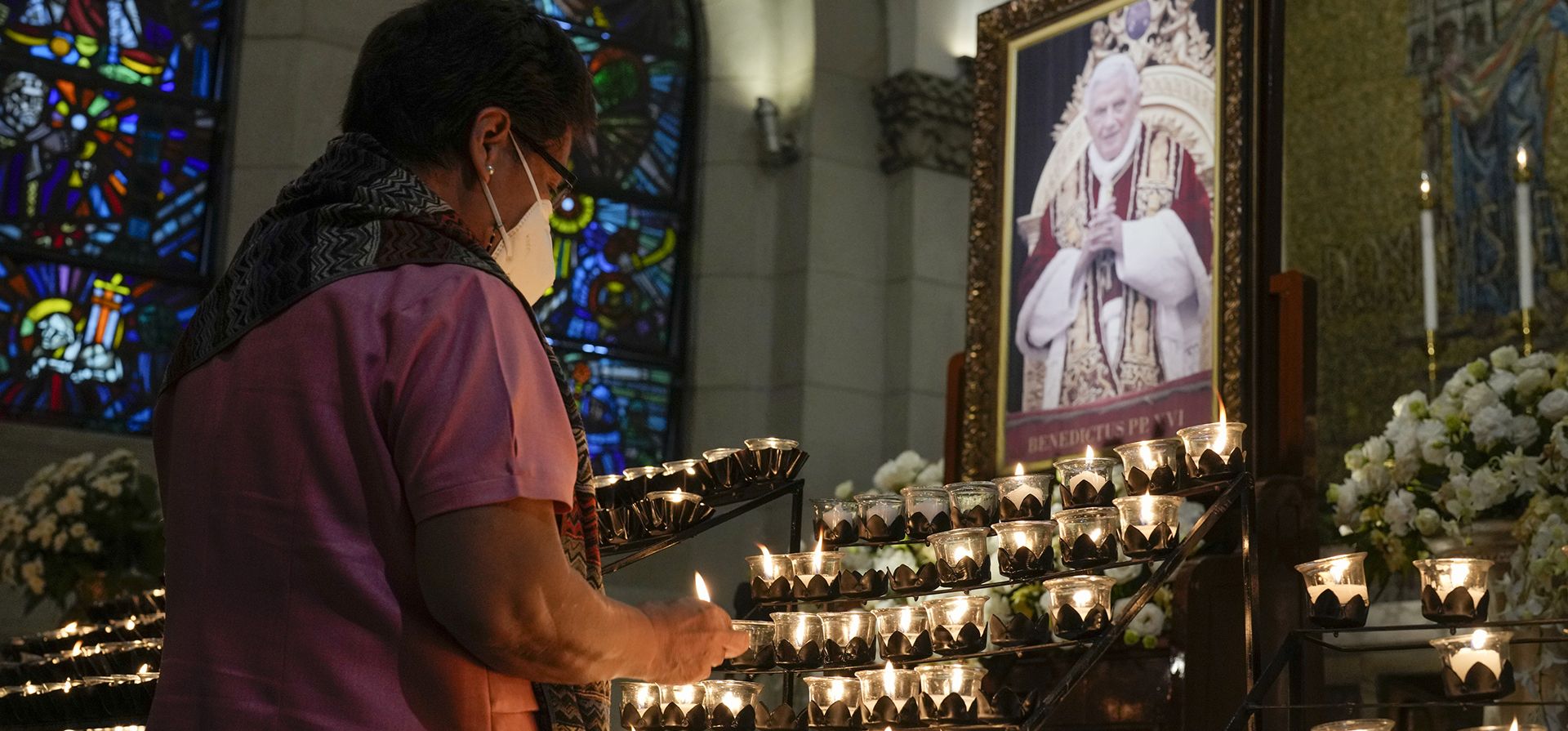 Un devoto ofrece una oración frente a un retrato del difunto Papa Emérito Benedicto XVI en la Catedral de Manila, Filipinas, en esta nación predominantemente católica el martes 3 de enero de 2023. (Foto AP/Aaron Favila)