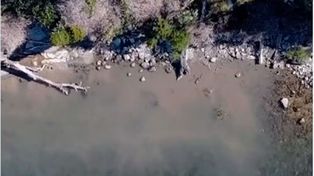 La mancha mugrienta en la orilla del lago tomada a través de un drone.