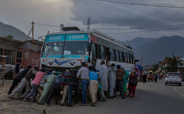 Pasajeros empujan el autobús en el que viajaban después de que tuviera alguna falla en el motor en Kangan