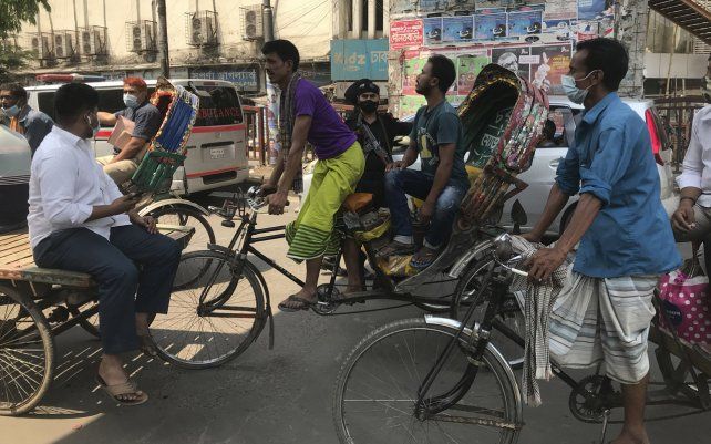 Conductores de rickshaw (bicitaxis) de Bangladesh, se despliegan durante un bloqueo en Dhaka, Bangladesh. Las autoridades están aplicando un bloqueo durante una semana a partir del lunes, cerrando centros comerciales y transporte, para ayudar a frenar la propagación del coronavirus a medida que avanza.