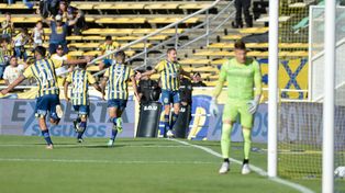 Marco Ruben ya convirtió, lo celebra frente a los hinchas y espera por el abrazo de sus compañeros.