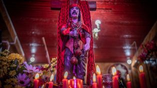 Santuario al Gauchito Gil con velas y ofrendas de color rojo que le dejan sus fieles.