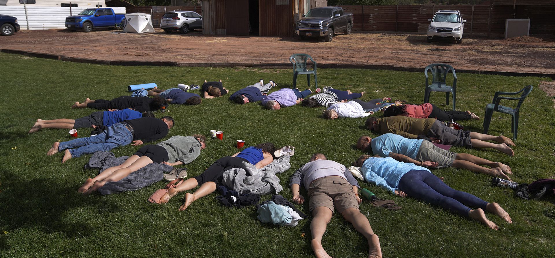 Los participantes se acostaron boca abajo en el césped durante un círculo de integración en un retiro de ayahuasca en Hildale, Utah, el sábado 15 de octubre de 2022. La Iglesia Hummingbird les pide a sus participantes que se unan en la integración, reflexión y discusión, para ayudar a interpretar los mensajes que recibieron de la ayahuasca. (Foto AP/Jessie Wardarski)