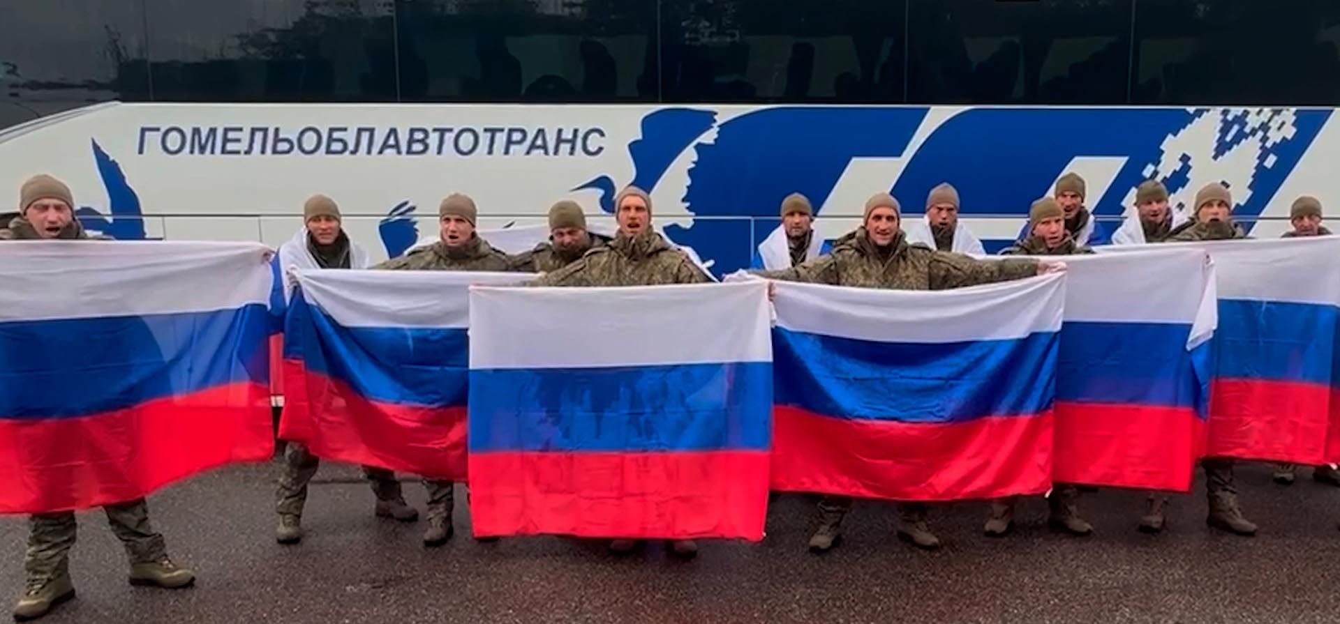 Militares rusos portan banderas nacionales frente a un autobús en una zona de intercambio en Bielorrusia tras regresar de su cautiverio durante un intercambio de prisioneros de guerra entre Rusia y Ucrania. (Servicio de Prensa del Ministerio de Defensa de Rusia vía AP) Militares rusos portan banderas nacionales frente a un autobús en una zona de intercambio en Bielorrusia tras regresar de su cautiverio durante un intercambio de prisioneros de guerra entre Rusia y Ucrania. (Servicio de Prensa del Ministerio de Defensa de Rusia vía AP)