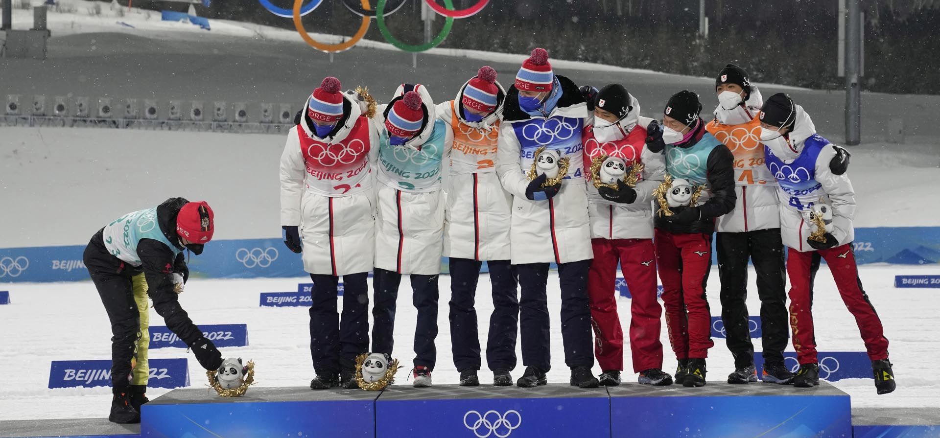 Los finalistas de la medalla de plata de Alemania colocan un premio Bing Dwen Dwen para su compañero de equipo desaparecido junto a los finalistas de la medalla de oro de Noruega y los finalistas de la medalla de bronce de Japón durante una ceremonia, el jueves 17 de febrero de 2022, en Zhangjiakou, China.