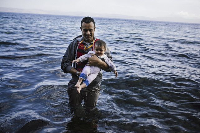 Conmovedor. Un migrante llega a la isla griega de Lesbos con su hijita luego de bajarse de un bote de goma. (NA)