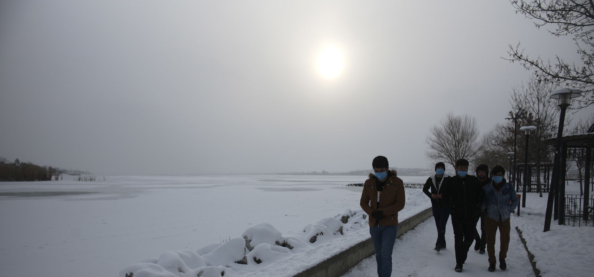 La gente pasa frente al lago congelado Mogan en el distrito de Golbasi, en Ankara, Turquía. Los equipos de rescate en Estambul y Atenas cavaron a través de la nieve y el hielo el martes para despejar las carreteras paralizadas y rescatar a las personas atrapadas durante la noche en sus automóviles después de las tormentas de nieve y un frente frío masivo que paralizó gran parte de Turquía y Grecia.