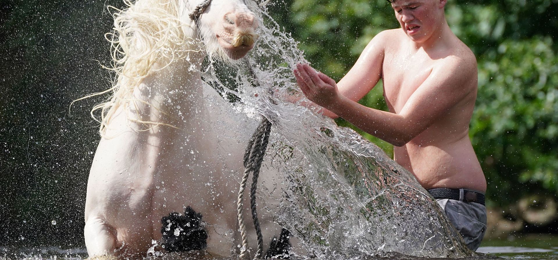 Un hombre lava su caballo en el río Eden en Appleby Horse Fair, la reunión anual de gitanos y viajeros en Appleby, Cumbria, Inglaterra.