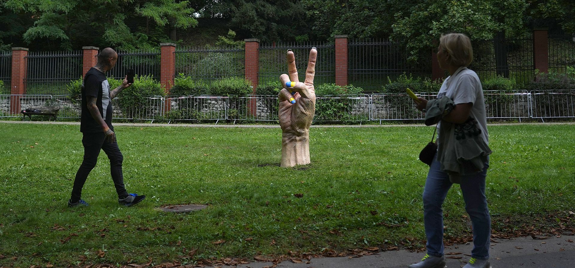 Personas toman fotografías de una estatua de una mano con uñas pintadas con los colores nacionales de Ucrania que se colocó frente a la embajada rusa en Praga, República Checa, el miércoles 24 de agosto de 2022. Los líderes europeos prometen un apoyo inquebrantable a Ucrania como el país devastado por la guerra celebra su Día de la Independencia.